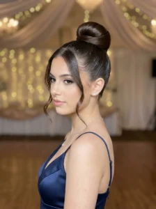 Sleek high bun with minimal tendrils prom hairstyle