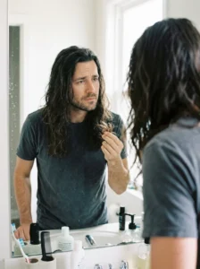 Man checking overgrown long hair and common maintenance mistak
